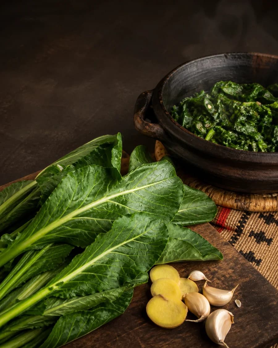 Fresh collard greens, ginger, garlic, and cooked Ethiopian gomen